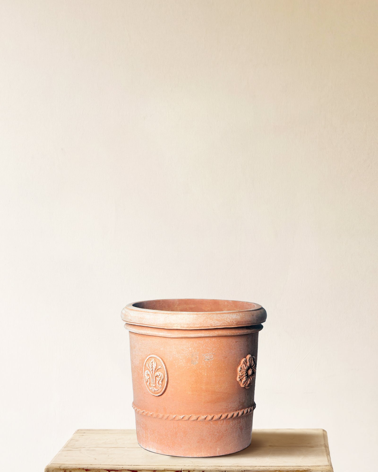 Italian terracotta planter with tall cylindrical form, projecting rim, raised medallion and rope band detail, made in Impruneta, 17" x 19"