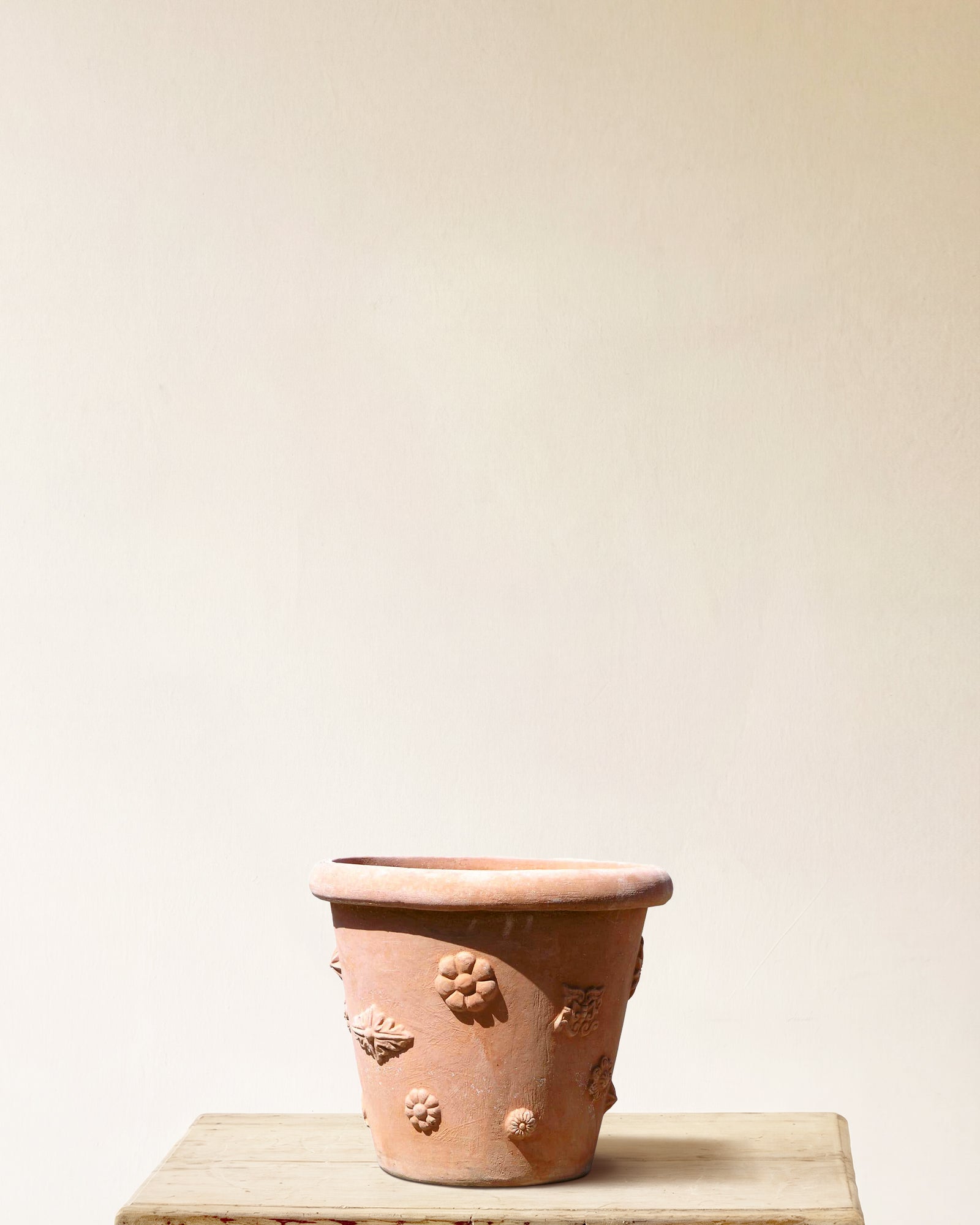 Italian terracotta planter with tapered form and scattered floral relief motifs, made in Impruneta, 16" x 16"