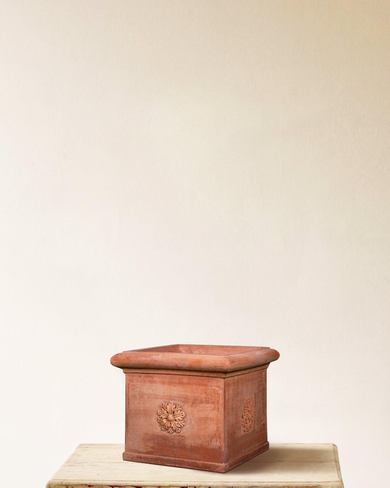 Italian terracotta square planter with carved rosette on each face, made in Impruneta, 18" x 16", angled view